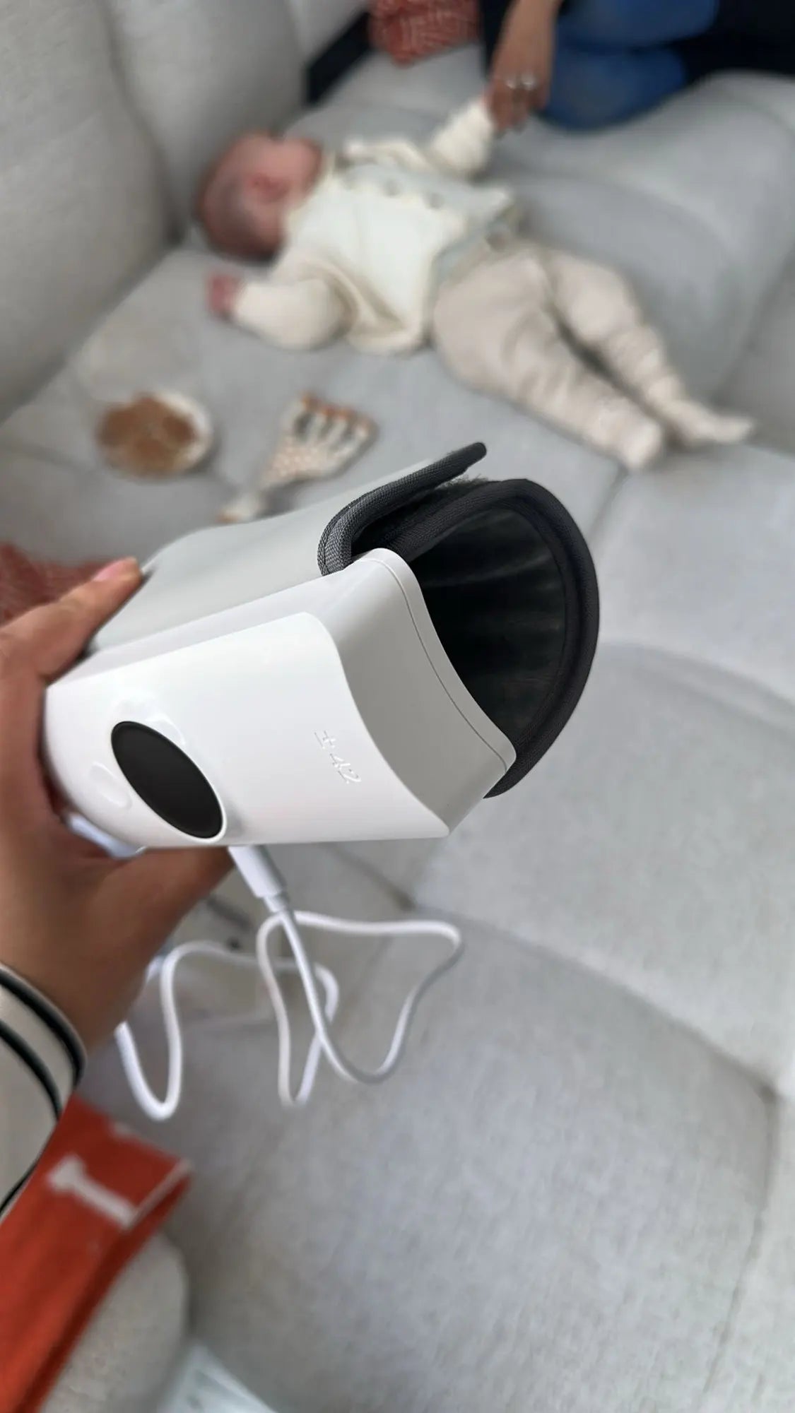 baby bottle warmer with a child playing on a couch in the background